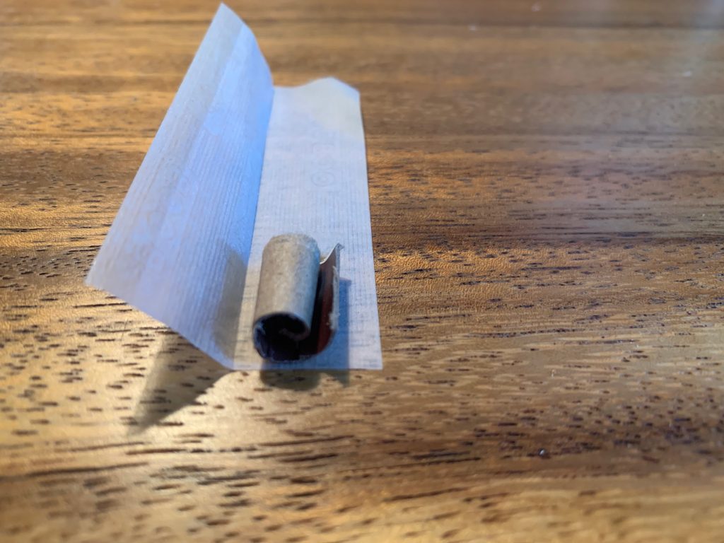 The cardboard filter is placed facing towards the inside of the paper and the adhesive line facing towards the one rolling the joint.